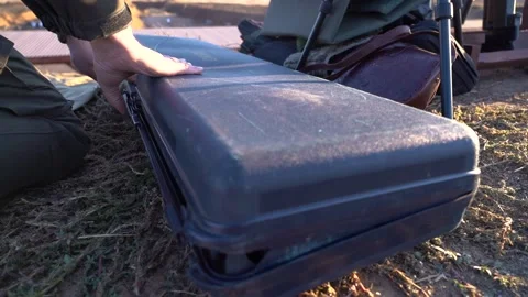 Opening the case containing the sniper rifle Stock Footage 228056070