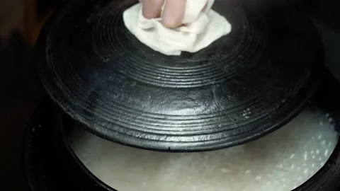 Opening Cast Iron Pot Lid to Reveal Boiling Broth with Steam Stock Footage 335736338
