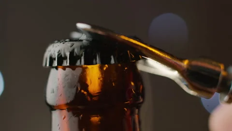 Opening cold bottle of beer with cap on black background. Macro Stock Footage 146126379