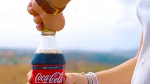 Opening a cold bottle of coca cola zero on a windy day - Close up Stock Footage 122177797