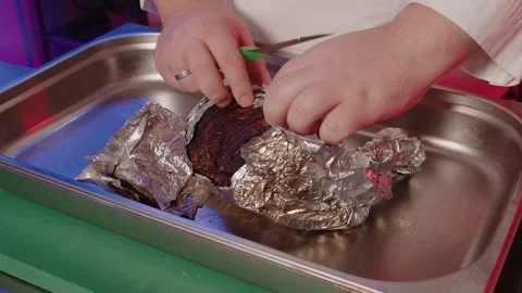 Opening up cooked meat in foil to see it nicely cooked. BBQ pork fresh off of Stock Footage 161599802