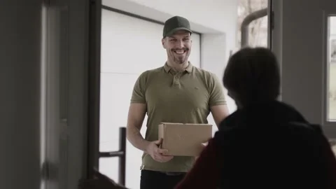 Opening the door for a courier delivering a package Stock Footage 149294070