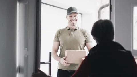 Opening the door for a courier delivering a package Stock Footage 149294099