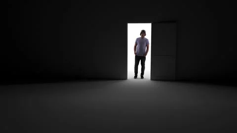 Opening the door in the dark, rays of light penetrate inside. There is a man sta Stock Footage 157023675