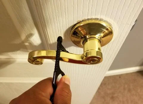 Opening the door with a tool to avoid touching the handle Photos