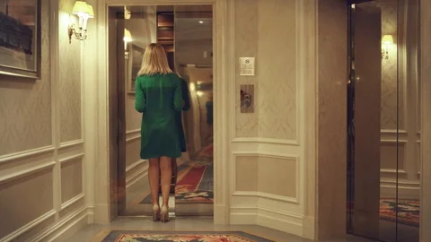 Opening empty elevator in hallway luxury hotel. Woman entering in lift car Stockbeeldmateriaal 87621599