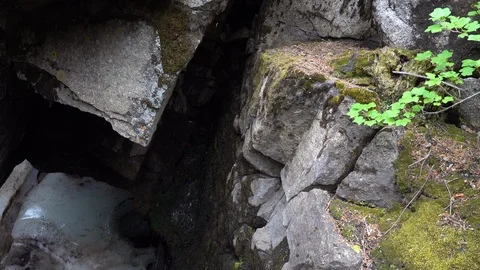 Opening to granite cave.  Ice at the bottom of a granite cave. Stockbeeldmateriaal 117581031