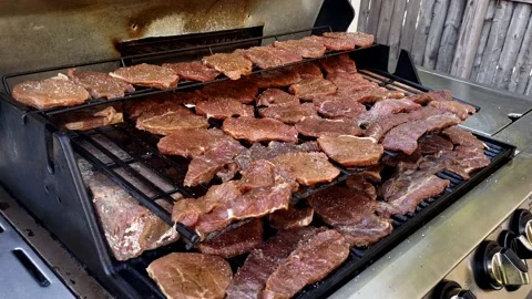 Opening grill lid and checking how thin beef slices being smoked 스톡 동영상 163238137