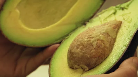 Opening Halved Avocado with Hands Stock Footage 154724122
