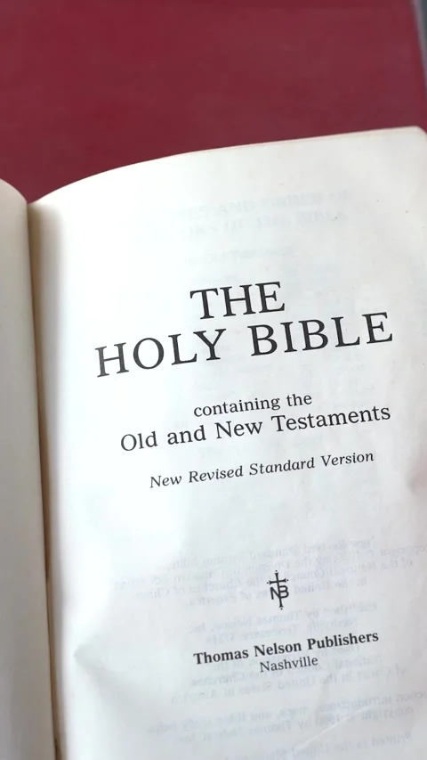 Opening Holy Bible, the New Revised Standard Version. Vertical video. Video stock 339042797