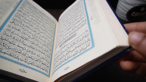 Opening the Holy Quran on a table Stock Footage 299197525