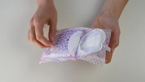 Opening an individually packed sanitary towel Stock Footage 144681058