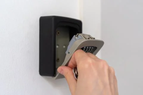 Opening key lockbox on apartment wall for contactless guest access 写真素材