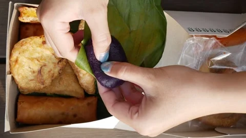 Opening kue bugis ubi ungu from the banana leaf. Indonesian traditional foo.. Stock Footage 294276220