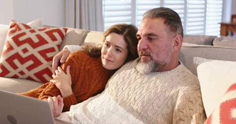 Opening laptop married couple browsing, tapping touchpad, pointing and laughing Stock Footage 317789680