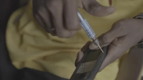 Opening an old button phone for repair Stock Footage 311068200