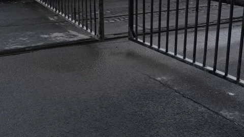 Opening or closing metal gates at the entrance to tram depot with visible tracks Stock-Footage 307431513