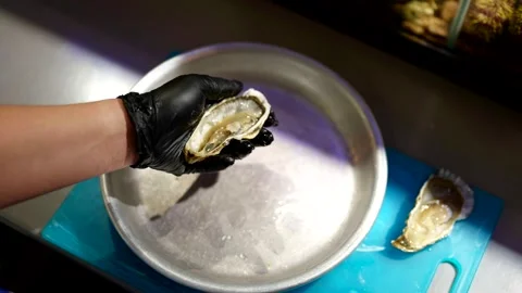 Opening an oyster with a special knife is a process that requires skill.  Stock Footage 301315473