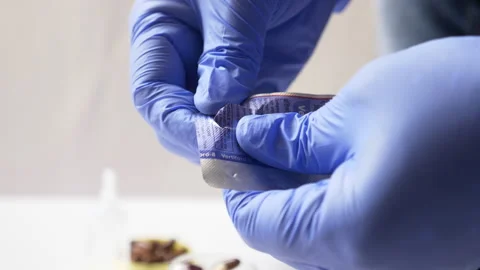 Opening the package and showing a pill or capsule in his hand Stock Footage 140025015