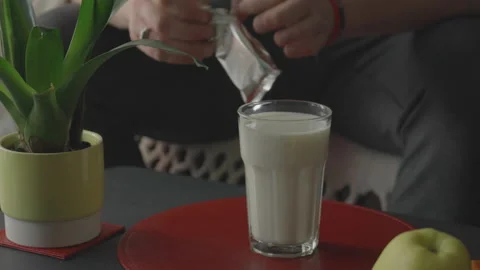 Opening a packet of cookies and dunking in a glass of milk Stock Footage 150818536