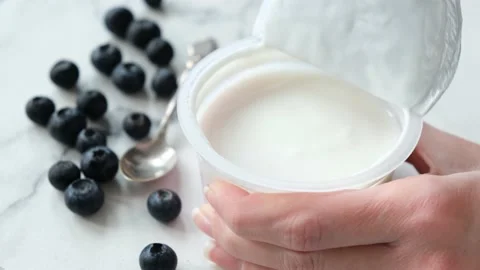 Opening plastic jar of yogurt Stock Footage 130524581