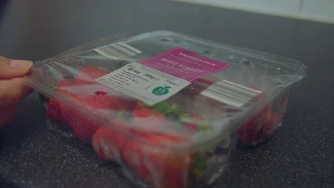 Opening a plastic pack of fruit Stock Footage 95186837