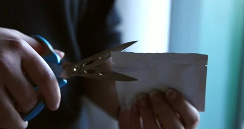 Opening a plastic white yeast packaging by cutting scissors by woman hand at Stock Footage 150198778