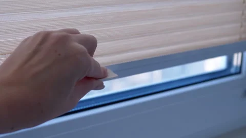 Opening pleated blinds on window Stock Footage 312011012
