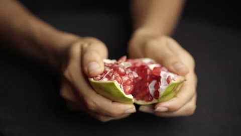 Opening a Pomegranate on a Dark Table Stock Footage 272184820