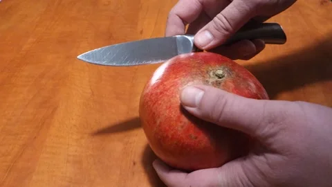 Opening a pomegranate with a knife Stock Footage 166124344