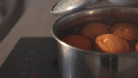 Opening pot lid to check boiling eggs on electric stove Stock Footage 312767230