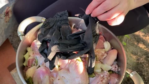 Opening pot with marinated meat and putting on black gloves before barbecue Stock Footage 345173990