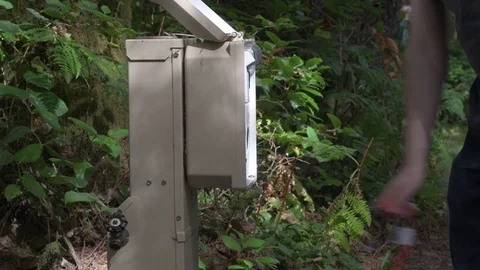 Opening a power hookup box, and removing a power cord at a campsite. Stock Footage 80550314