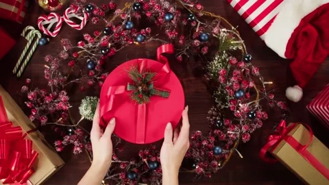Opening present box on table top view. Hands unpacking red gift in christmas Stock Footage 163681381