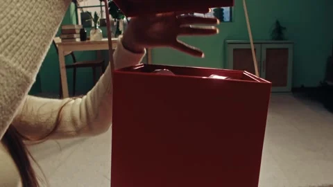 Opening a Red Gift Box with White Ribbon in a Sunny Living Room 库存影片 331098931