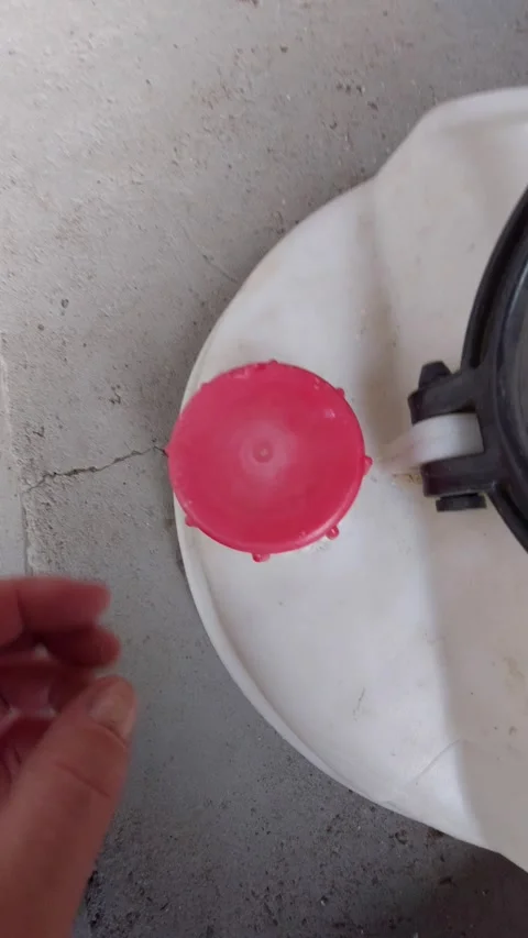 Opening a red plastic cap on a white chemical tank Stock Footage 333778281