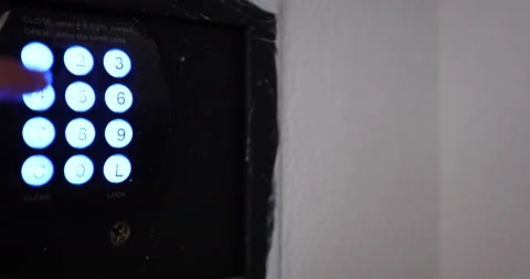 Opening the safe by entering the right combination by female hand in hotel room Stock Footage 165119357