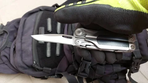 Opening sharp straight knife blade on heavy duty multitool, close up top view Stock Footage 346363965