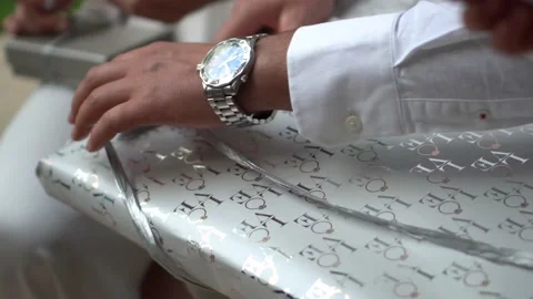 Opening a silver-wrapped present Video stock 232763589