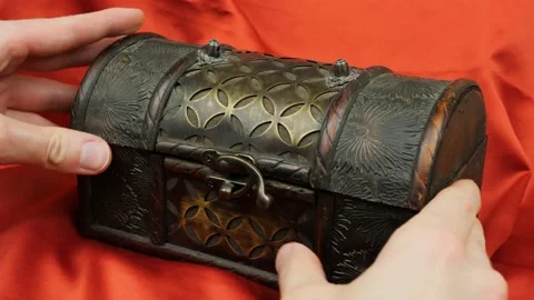 Opening a small treasure chest on red satin Video stock 152530136