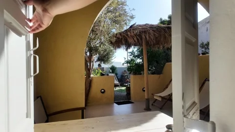 Opening small window to Greek patio paradise Stock Footage 329586151
