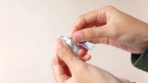 Opening a tablet of medicine on its package Stock Footage 151026238
