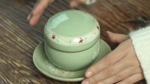 Opening Tea Cup Lid with Steam Rising on Table Close Up Stock Footage 335797588