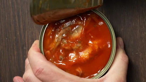 Opening a tin can of fish in tomato sauce top view Stockbeeldmateriaal 338278350