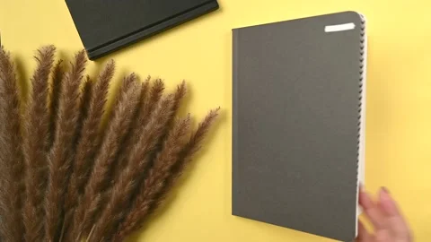 Opening a trendy notebook on yellow background for paper design. Stock Footage 163094979