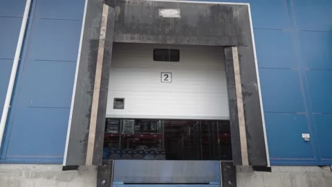 Opening the warehouse door. Large roll-up gates to the enterprise shooting from Stock Footage 179413632