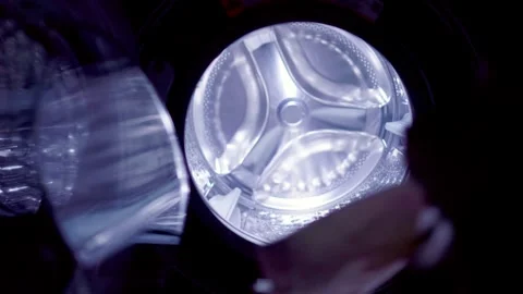 Opening washer machine and putting clothes in Stock Footage 305163629