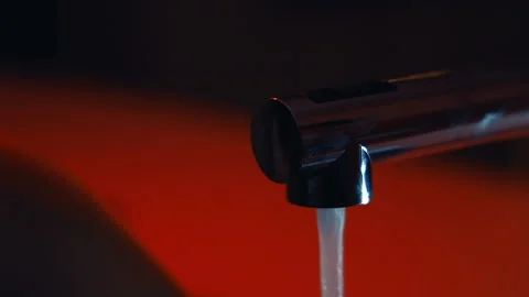 Opening water tap, with red background Stock Footage 151927184