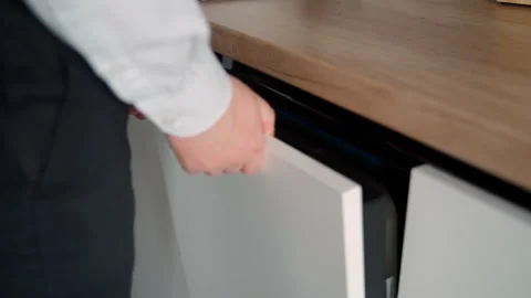 Opening the white built-in dishwasher door Stock Footage 153282499