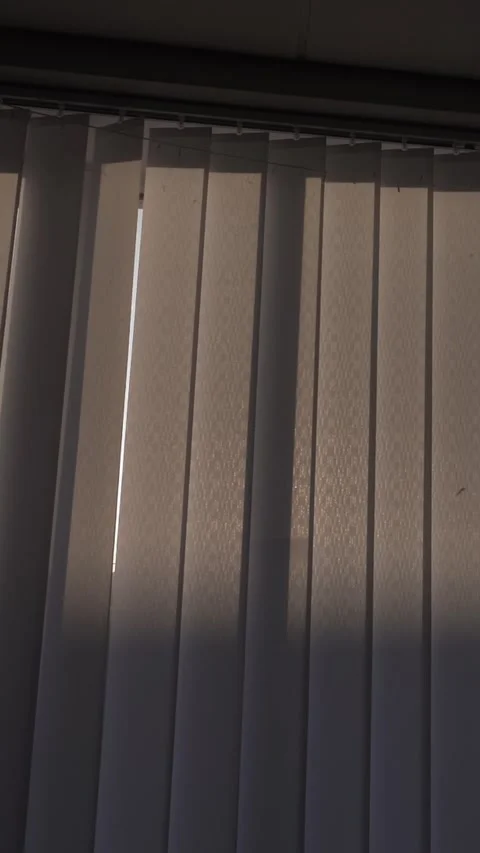 Opening window blinds through which the sun's rays appear. Stock Footage 324791389